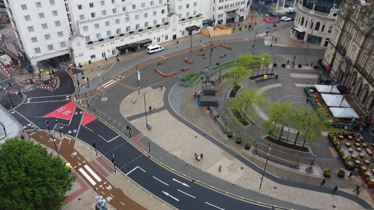 Birds eye view looking down on roads with trees and walkways in the middle