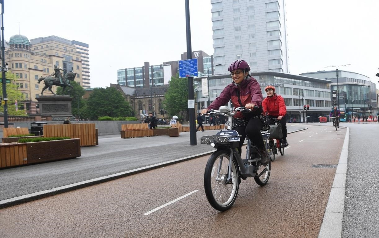 Woman riding bike through traffic