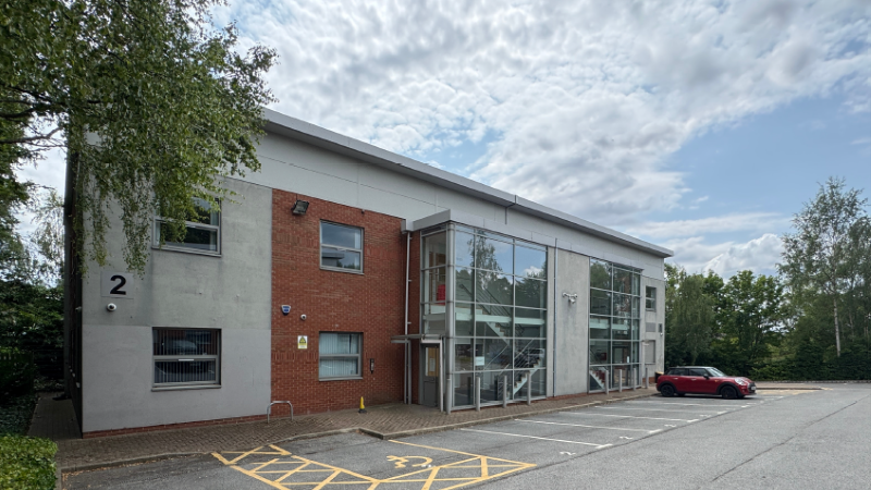 Photograph of the front of Units 1 and 2 Killingbeck Court showing a 2 storey detached office block with parking area and trees to boundaries of plot