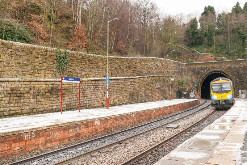 train coming out of a tunnel approaching the train station platform