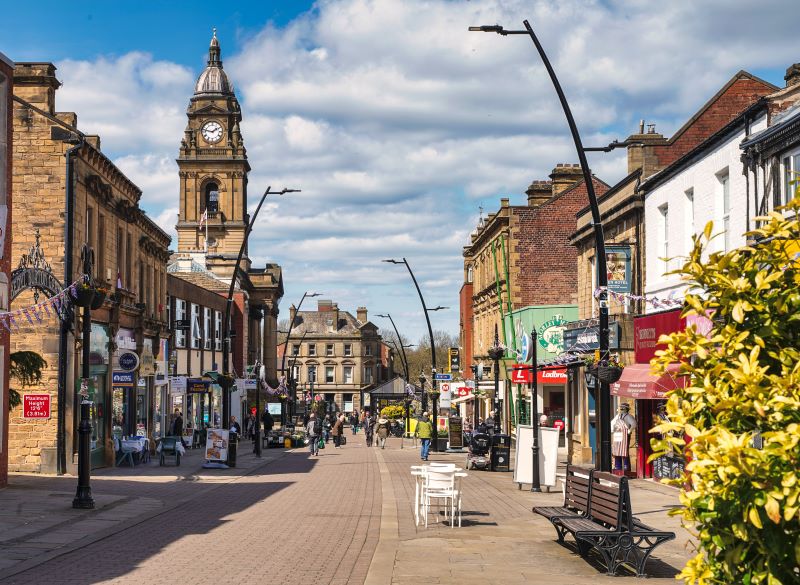 High street with shops on either side and town hall on the left