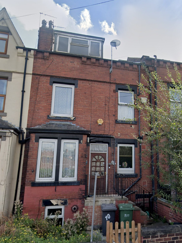 Image shows front a of four-storey, red-brick terraced house