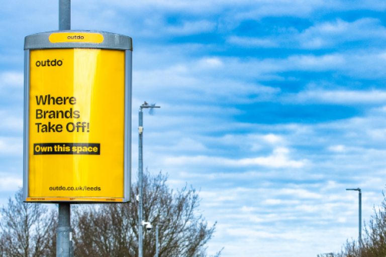 Image shows Outdo advertising sign on lamp post by main road